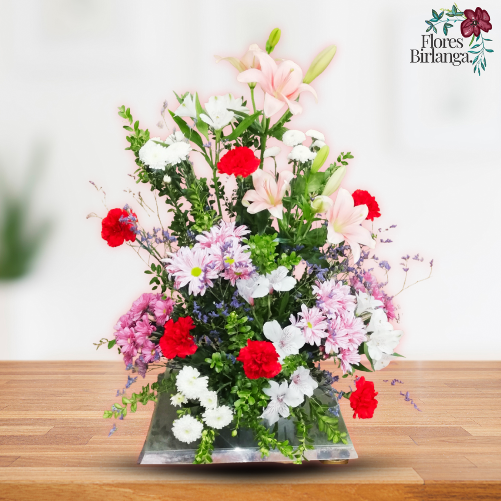 Arreglo floral elevado para Todos los Santos con lirios rosados, claveles rojos y crisantemos en una base metálica, de Flores Birlanga.