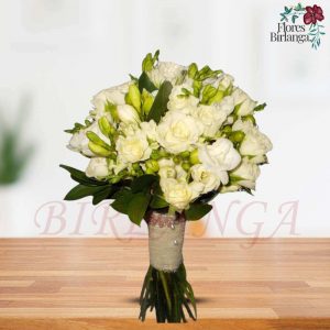 Diseño de ramo de novia blanco y elegante con rosas blancas, freesia y un mango artesanal decorado con encaje y perlas en el taller de Flores Birlanga