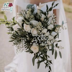 Ramo de novia silvestre y natural con texturas de rosas blancas, paniculata, cardos azules y foliage de eucalipto en taller de Flores Birlanga